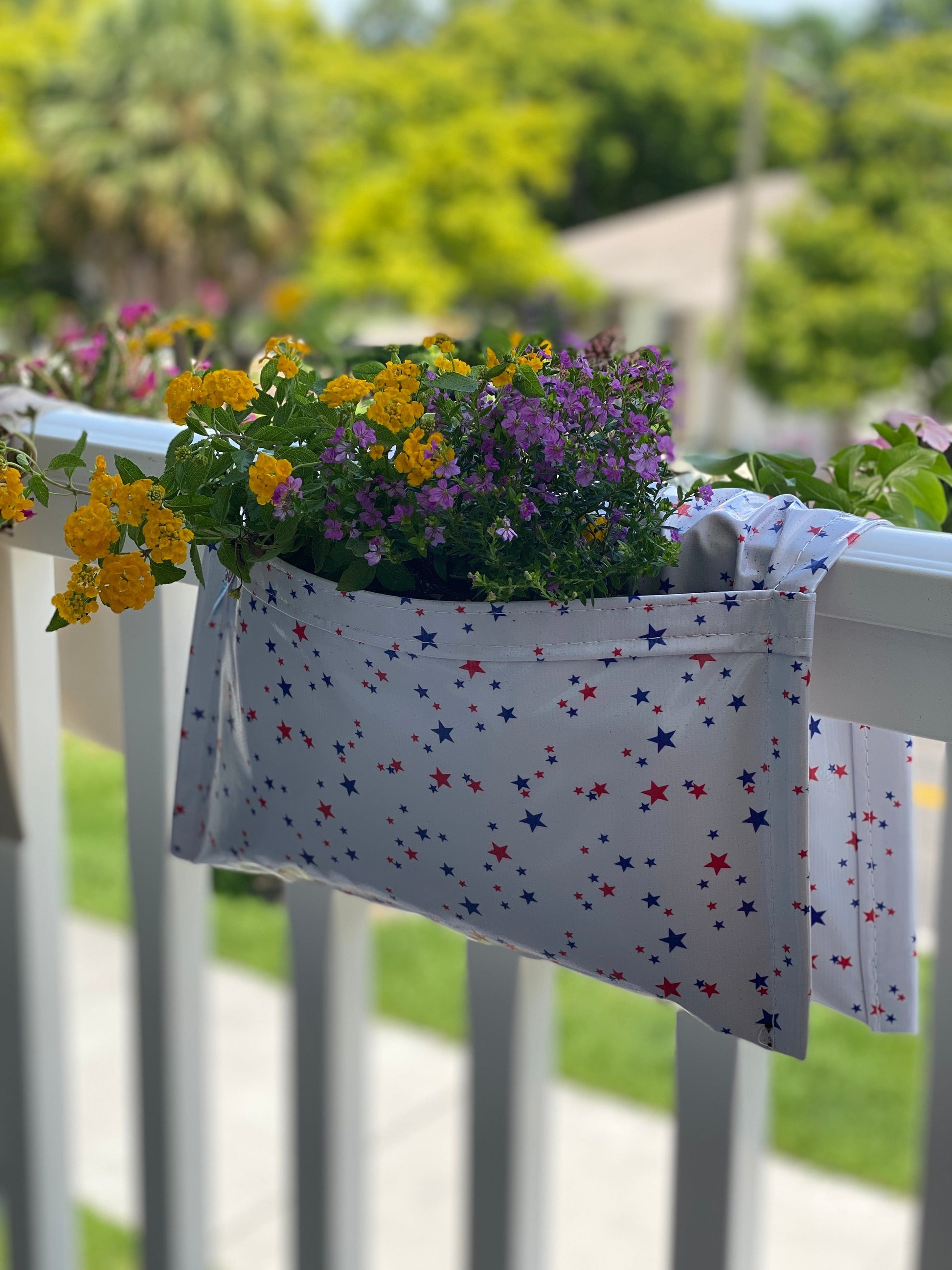 White with small blue and red stars railing planter for flowers, plants and herbs like a saddle bag and hangs from the railing of a patio, balcony, deck or terrance.