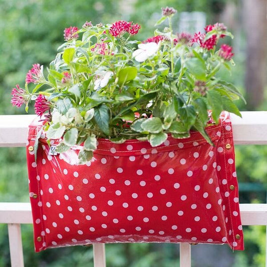 Red with white polkadots railing planter for flowers, plants and herbs like a saddle bag and hangs from the railing of a patio, balcony, deck or terrance.